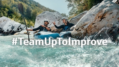 在激流中奋力挥浆的双人皮划艇运动员