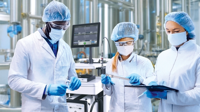 Scientists with a Raman spectroscopy system in the background