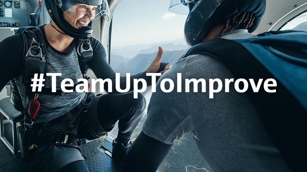 两名跳伞员正准备从飞行中的飞机跳下。其中一人向同伴竖起了大拇指。