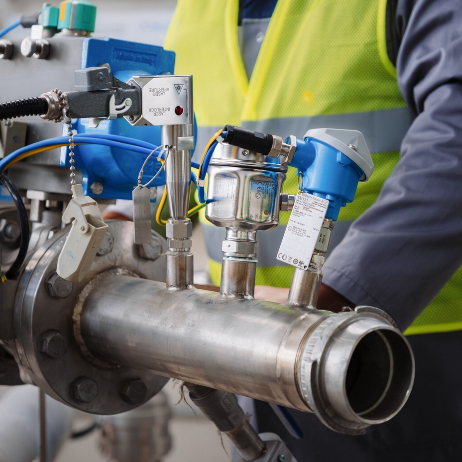 Technician next to Endress+Hauser Raman and other devices installed in a disconnected pipe