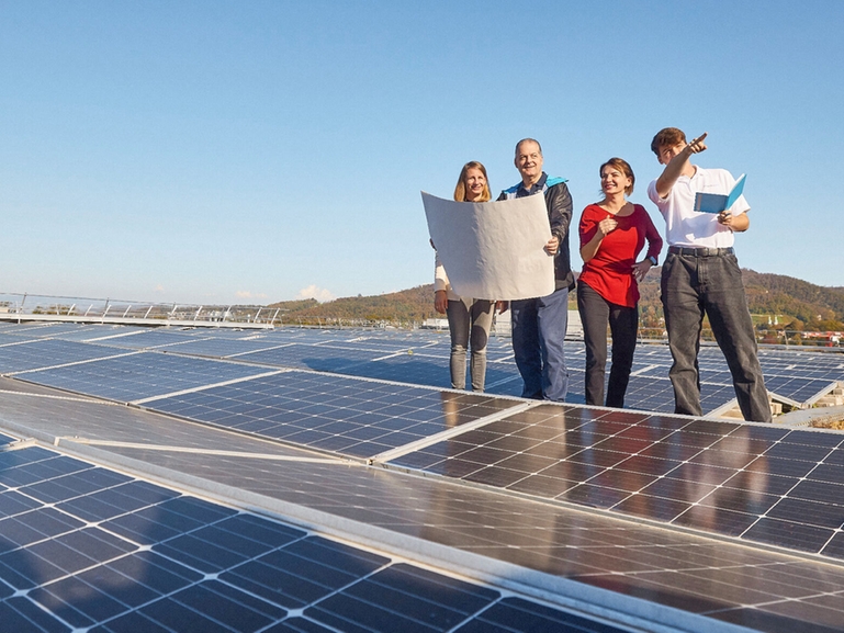 Group of people in front of solar panels