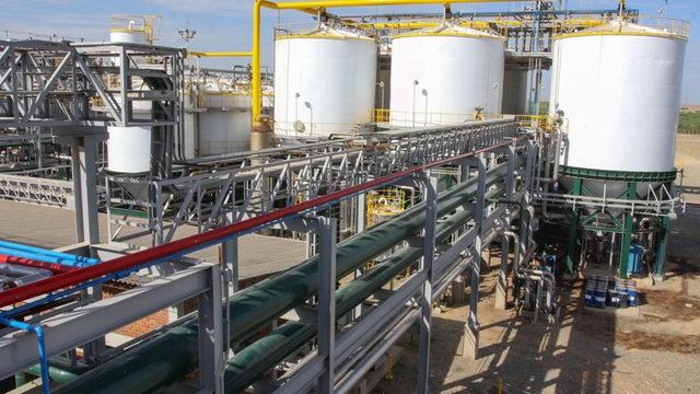 Industrial biofuel production facility with storage tanks, pipelines and process infrastructure.