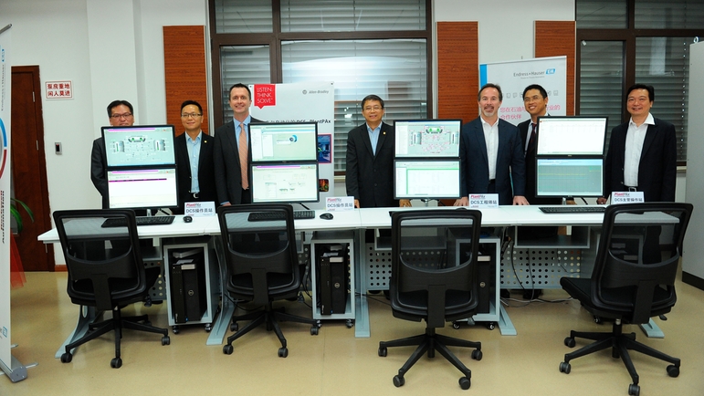 双方领导在罗克韦尔控制与信息系统演示台旁合影