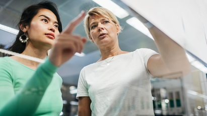 两名女员工正在屏幕前分析数据