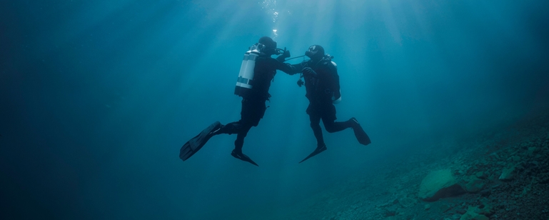 水下场景：一名潜水员正在救援缺氧的同伴